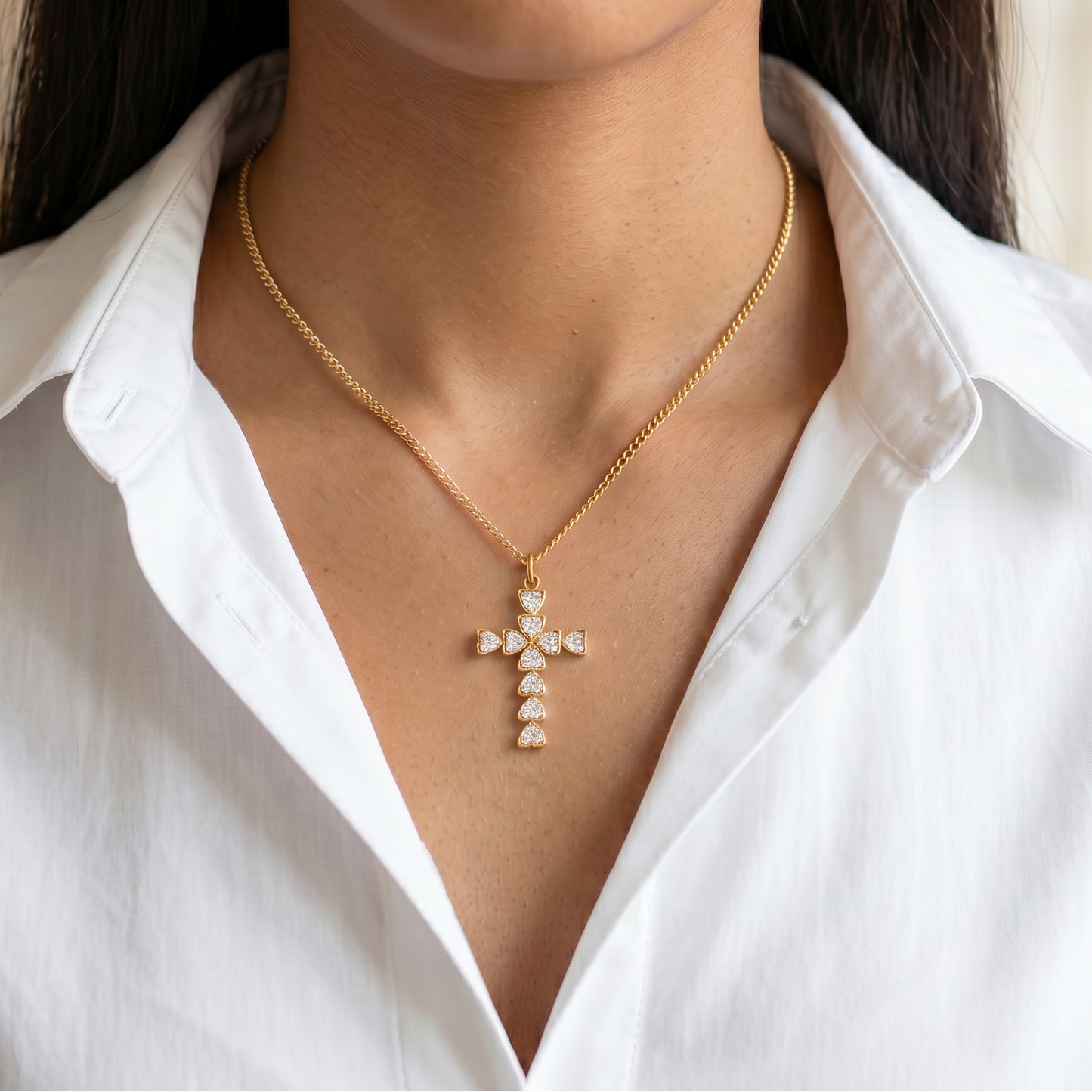 colgante en forma de cruz reinterpreta un diseño icónico con un giro actual: está formado por circonitas en talla corazón que aportan un extra de estilo y personalidad